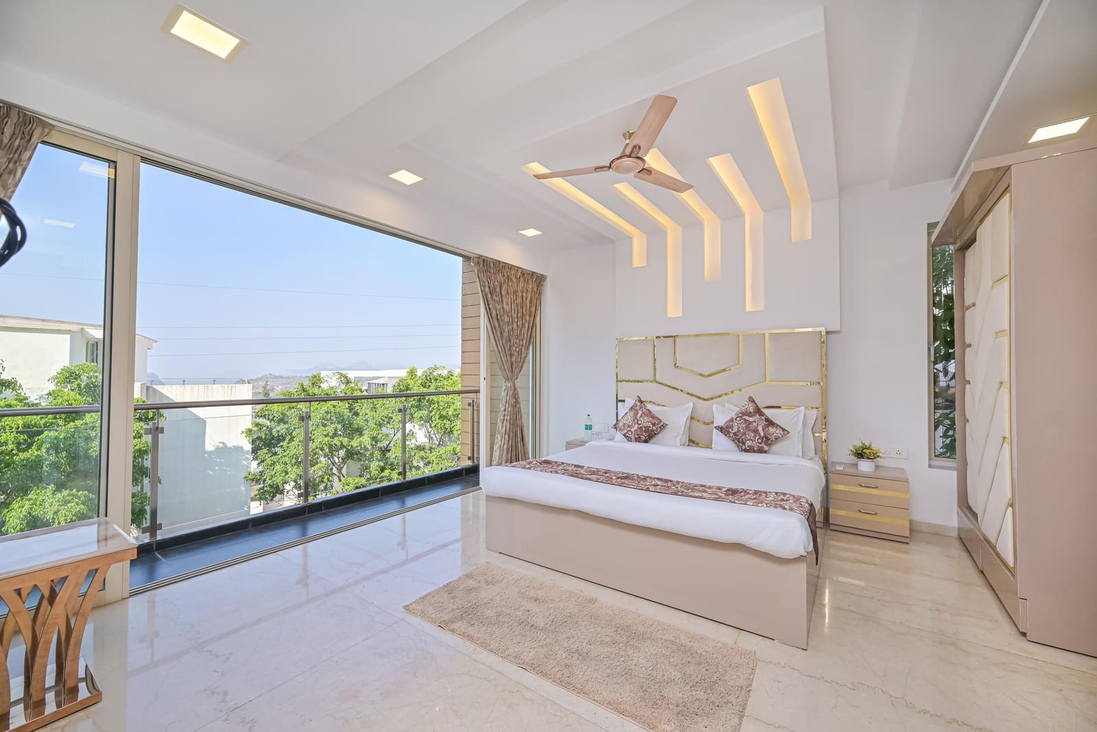 A bedroom with a wide window and morning light